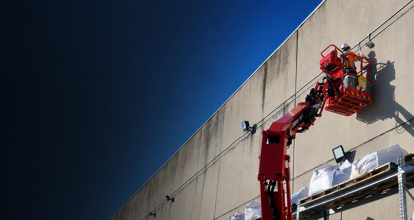 Security technician installing a CCTV camera on a commercial building